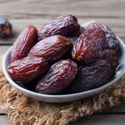 Datteln in Schale auf Holztisch